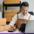 ¿Cómo vender más en Hot Sale? 2 Emprendedor sonriente revisando pedidos y calculando ventas en su negocio: cómo vender más en Hot Sale